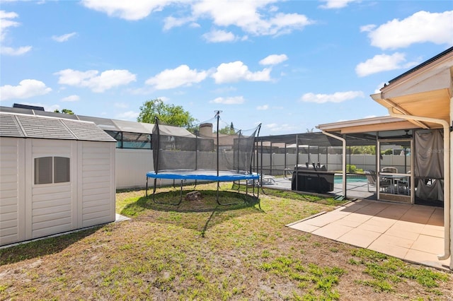 view of yard with a shed, an outdoor structure, a patio area, a trampoline, and a fenced in pool