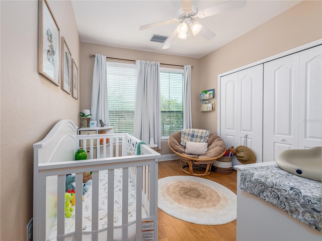 2709 Via Cipriani Unit 522B, Clearwater, FL 33764 - bedroom featuring a closet, a ceiling fan, visible vents, a nursery area, and wood finished floors