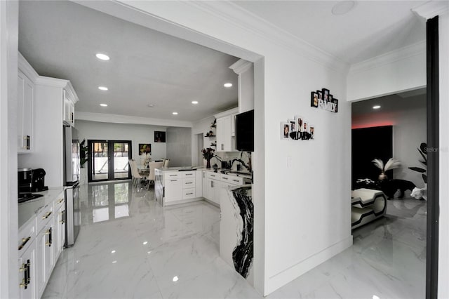 kitchen featuring marble finish floor, crown molding, freestanding refrigerator, and a peninsula