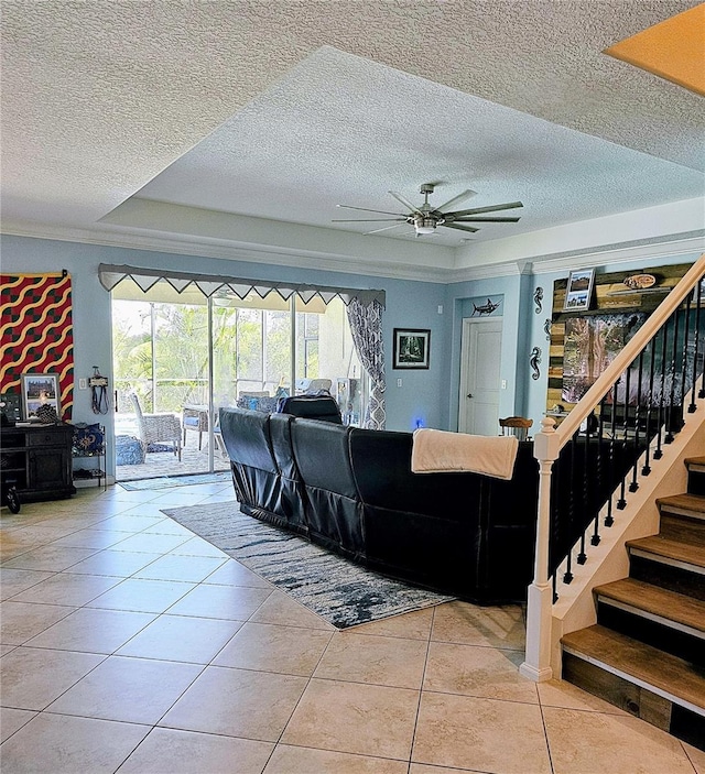 living room featuring plenty of natural light, a textured ceiling, stairs, and ceiling fan