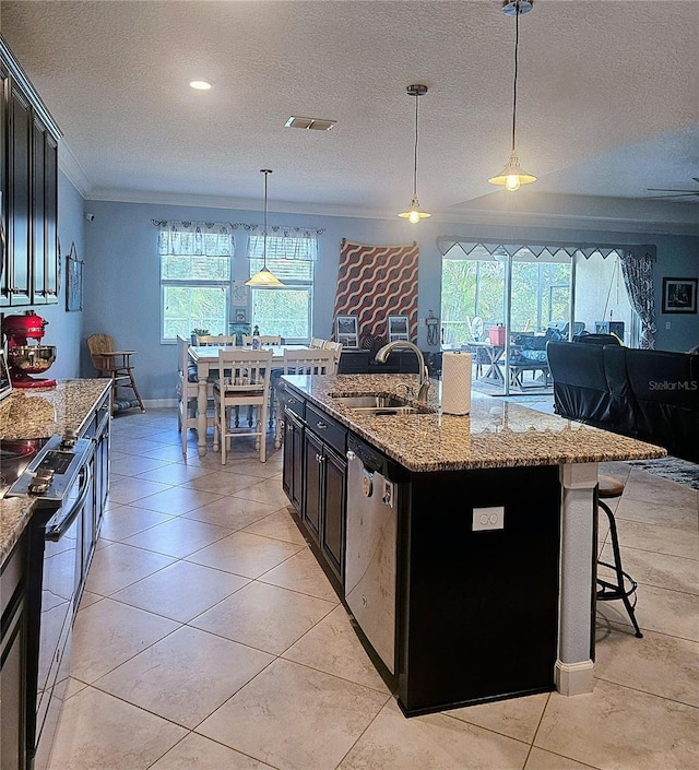 kitchen with a sink, dark cabinetry, a textured ceiling, crown molding, and stainless steel dishwasher