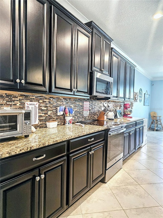 kitchen with crown molding, dark cabinets, and stainless steel appliances