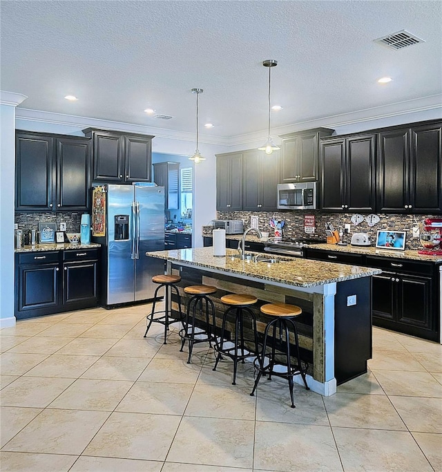 kitchen featuring dark cabinets, visible vents, and stainless steel appliances