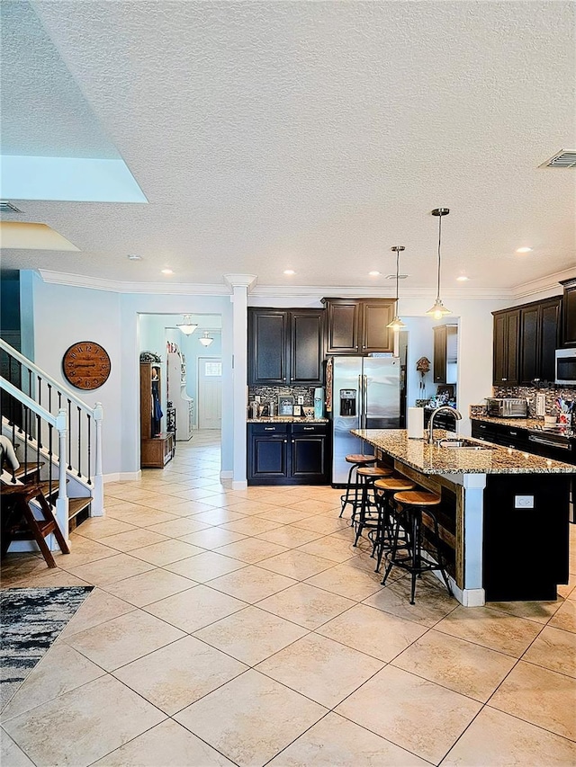 kitchen featuring a kitchen bar, decorative backsplash, ornamental molding, and appliances with stainless steel finishes