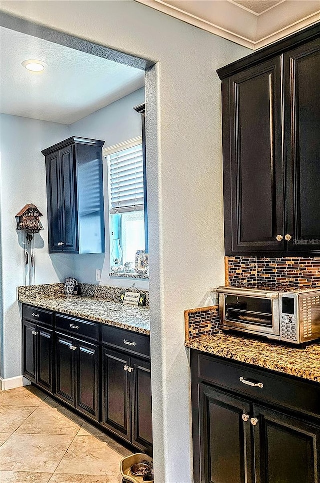 bar with backsplash, light tile patterned flooring, baseboards, and a toaster