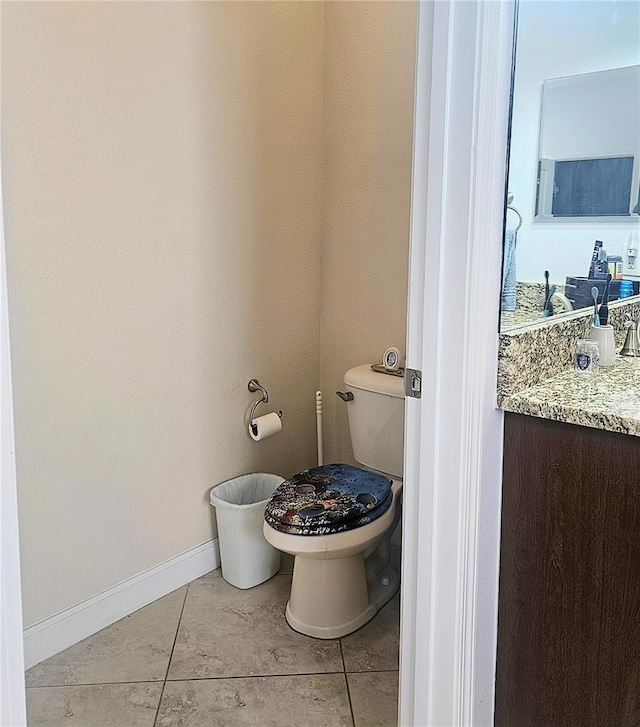 bathroom featuring toilet, vanity, and baseboards