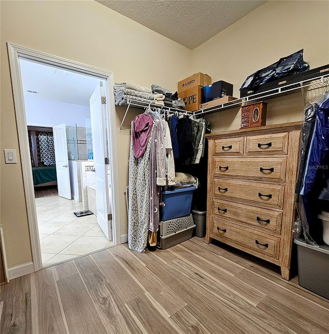 walk in closet with light wood-style floors