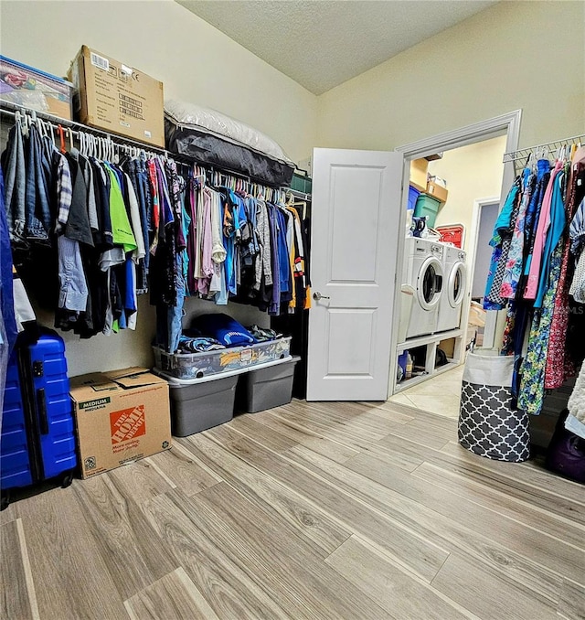 walk in closet with washer and dryer and wood finished floors