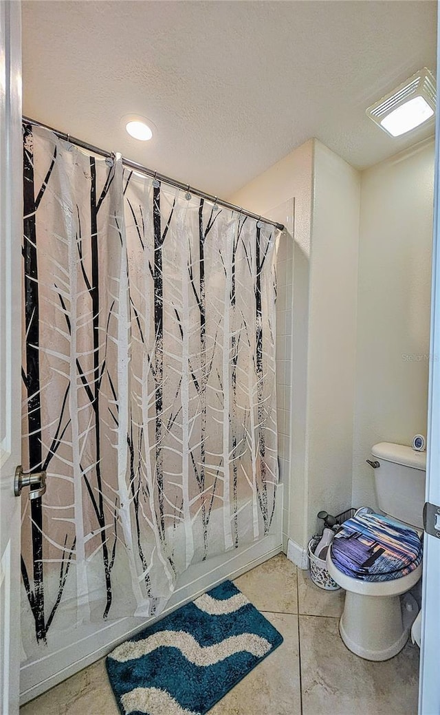 bathroom with toilet, curtained shower, concrete floors, and a textured ceiling