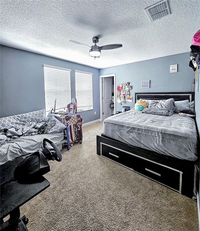 carpeted bedroom with visible vents, a ceiling fan, and a textured ceiling