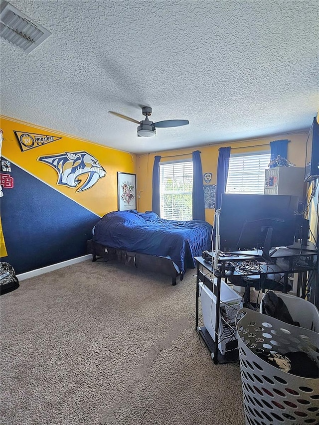 bedroom with visible vents, baseboards, a ceiling fan, a textured ceiling, and carpet flooring
