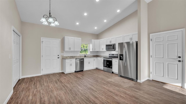 kitchen with white cabinets, light wood-style flooring, stainless steel appliances, and a chandelier
