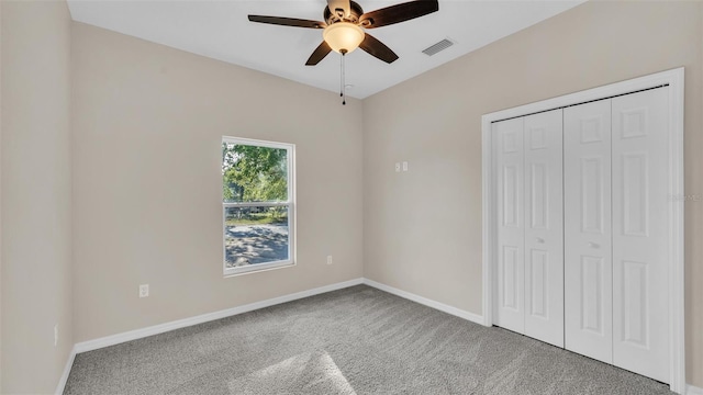 unfurnished bedroom featuring baseboards, carpet floors, ceiling fan, visible vents, and a closet