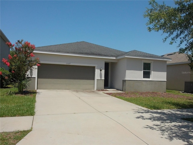 11527 Southern Creek Dr, Gibsonton, FL 33534 - single story home featuring an attached garage, concrete driveway, stucco siding, and central air condition unit