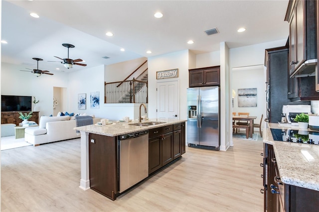 13008 Eagles Entry Dr, Odessa, FL 33556 - kitchen with stainless steel appliances, a sink, dark brown cabinetry, light wood-style flooring, and recessed lighting