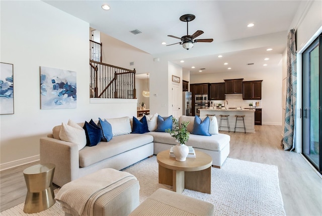 13008 Eagles Entry Dr, Odessa, FL 33556 - living area with light wood-style floors, a ceiling fan, stairs, baseboards, and recessed lighting