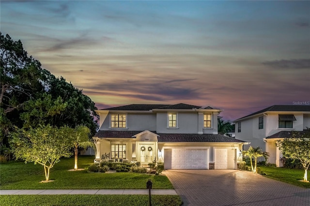 13008 Eagles Entry Dr, Odessa, FL 33556 - traditional-style house featuring decorative driveway, stucco siding, a front lawn, and an attached garage