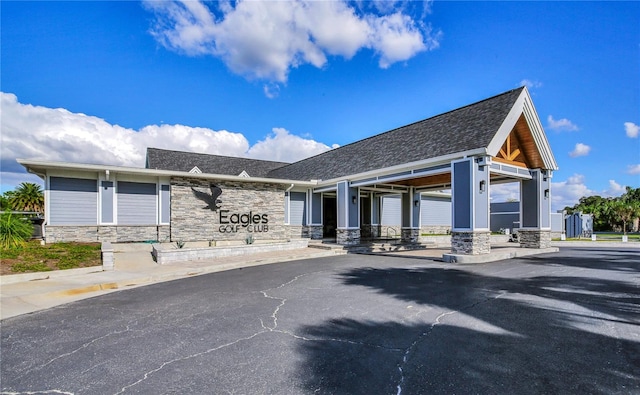 13008 Eagles Entry Dr, Odessa, FL 33556 - rear view of house featuring stone siding and roof with shingles