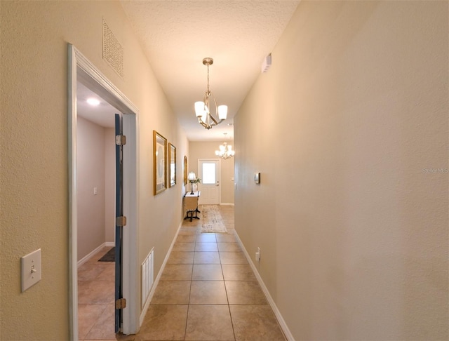 6416 Cobble Bliss St, Zephyrhills, FL 33541 - hall with an inviting chandelier, light tile patterned floors, baseboards, and visible vents
