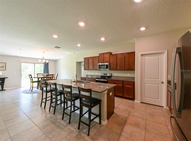 6416 Cobble Bliss St, Zephyrhills, FL 33541 - kitchen featuring a kitchen breakfast bar, a center island with sink, stainless steel appliances, light tile patterned floors, and visible vents