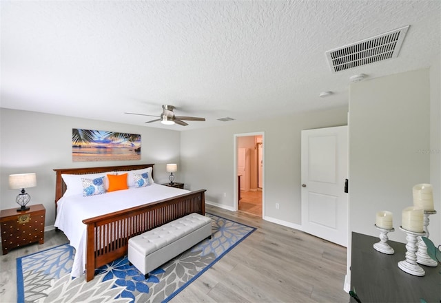 6416 Cobble Bliss St, Zephyrhills, FL 33541 - bedroom featuring a ceiling fan, a textured ceiling, light wood-style flooring, baseboards, and visible vents
