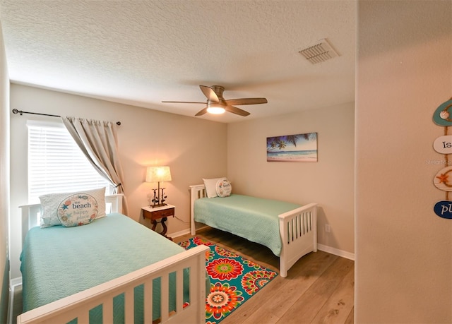 6416 Cobble Bliss St, Zephyrhills, FL 33541 - bedroom featuring baseboards, visible vents, light wood-style floors, and a textured ceiling