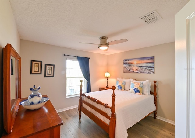 6416 Cobble Bliss St, Zephyrhills, FL 33541 - bedroom with a textured ceiling, visible vents, baseboards, ceiling fan, and wood finished floors