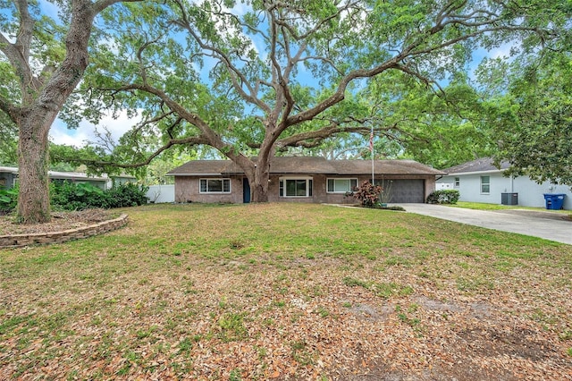 1308 W Perdiz St, Tampa, FL 33612 - ranch-style house featuring concrete driveway, a front lawn, central air condition unit, fence, and a garage