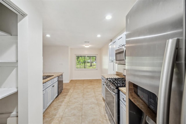 1308 W Perdiz St, Tampa, FL 33612 - kitchen with baseboards, recessed lighting, appliances with stainless steel finishes, light stone counters, and light tile patterned floors