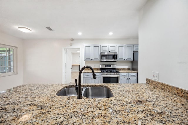 1308 W Perdiz St, Tampa, FL 33612 - kitchen with recessed lighting, light stone counters, visible vents, a sink, and appliances with stainless steel finishes