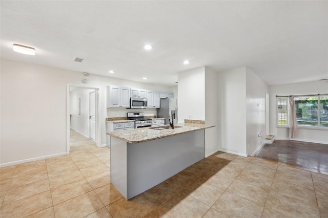 1308 W Perdiz St, Tampa, FL 33612 - kitchen featuring a peninsula, light stone counters, recessed lighting, and appliances with stainless steel finishes