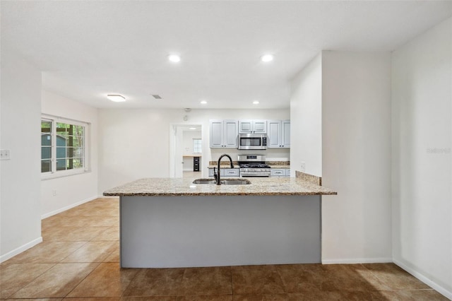 1308 W Perdiz St, Tampa, FL 33612 - kitchen featuring recessed lighting, light stone counters, a sink, a peninsula, and appliances with stainless steel finishes