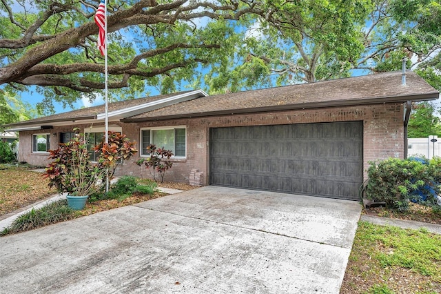 1308 W Perdiz St, Tampa, FL 33612 - ranch-style house featuring concrete driveway, brick siding, roof with shingles, and a garage