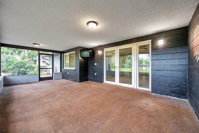1308 W Perdiz St, Tampa, FL 33612 - carpeted empty room featuring concrete block wall and a textured ceiling
