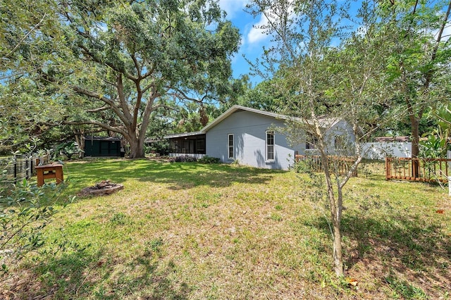 1308 W Perdiz St, Tampa, FL 33612 - view of yard with a sunroom, an outdoor fire pit, and fence