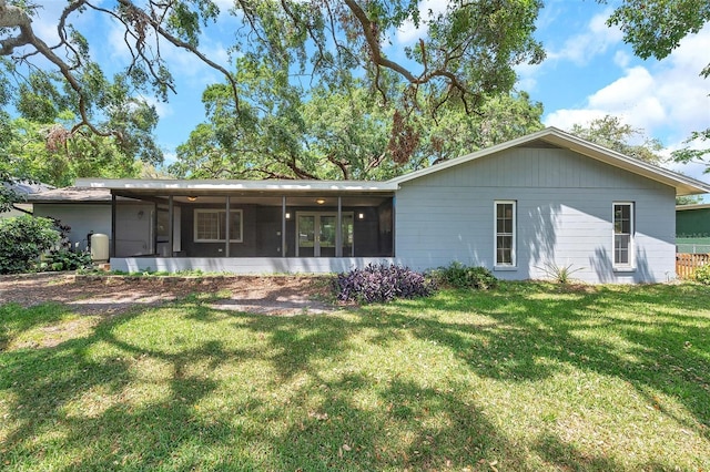 1308 W Perdiz St, Tampa, FL 33612 - rear view of house with a lawn and a sunroom