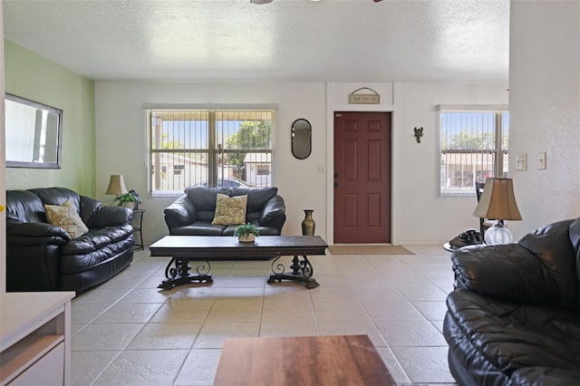 living area featuring a textured ceiling, tile patterned flooring, and a ceiling fan