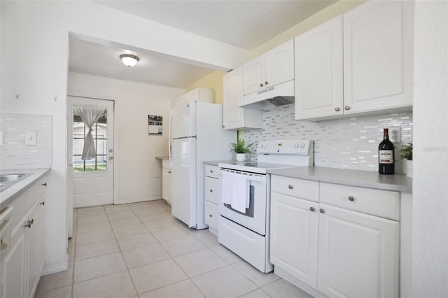 kitchen with under cabinet range hood, white cabinets, tasteful backsplash, and white appliances