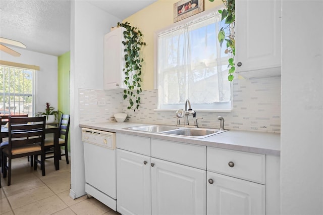 kitchen featuring light tile patterned flooring, a sink, tasteful backsplash, and dishwasher