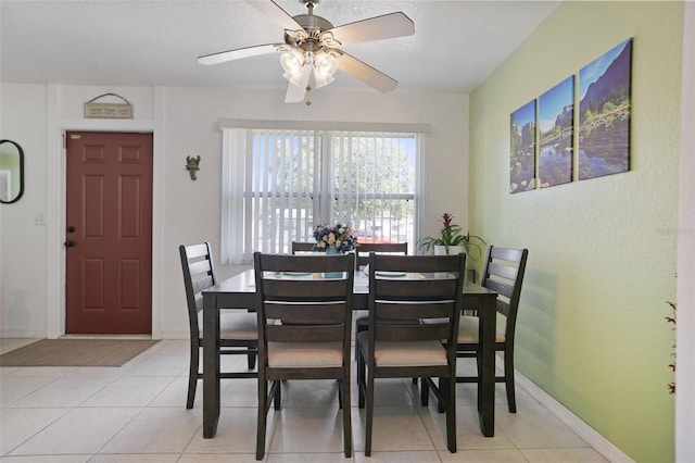 dining space featuring baseboards, light tile patterned floors, and a ceiling fan