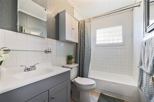 bathroom with tile walls, toilet, vanity, shower / tub combo with curtain, and a textured wall