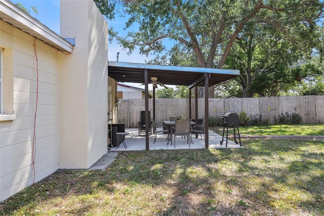 view of yard featuring a patio area, ceiling fan, and fence