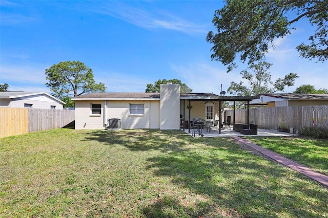 back of property with a fenced backyard, central AC unit, a yard, and a patio