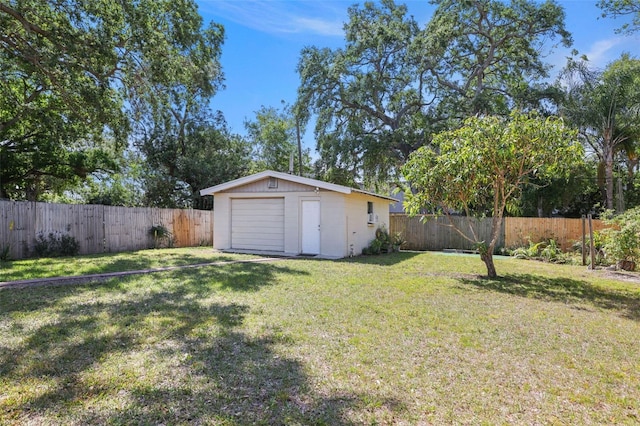 view of yard with a fenced backyard, a storage unit, an outbuilding, and a detached garage