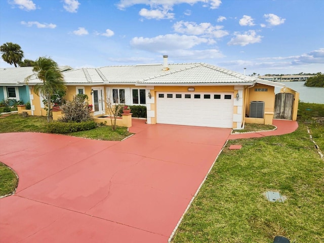 view of front of home with stucco siding, a front lawn, a tile roof, a garage, and concrete driveway