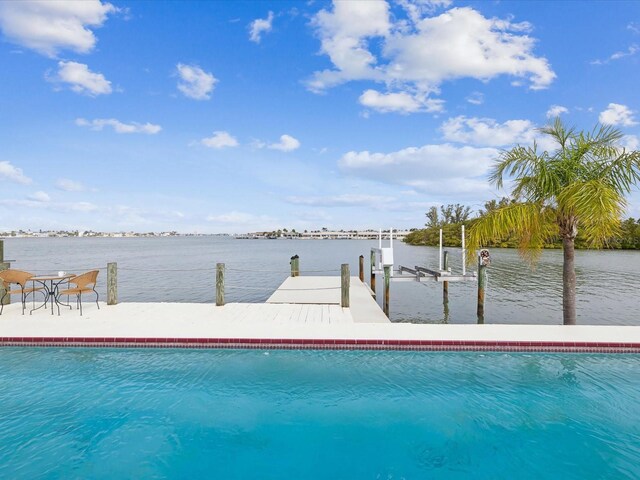 view of swimming pool featuring a water view, a boat dock, and boat lift
