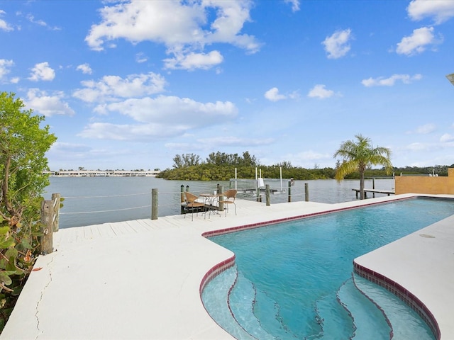 pool featuring a water view, a patio area, and a boat dock