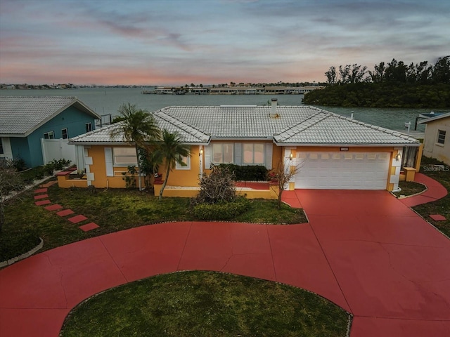 ranch-style home with an attached garage, driveway, stucco siding, and a tile roof