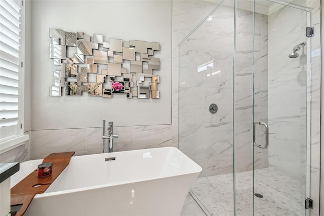 full bath featuring a marble finish shower, a soaking tub, and a sink