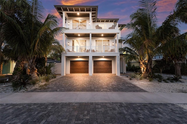 311 Spring Ave, Anna Maria, FL 34216 - coastal home featuring stucco siding, a garage, decorative driveway, and a balcony